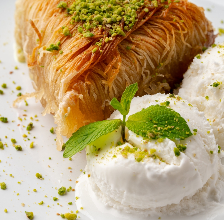 Close up photo of Turkish baklava served with ice cream on plate